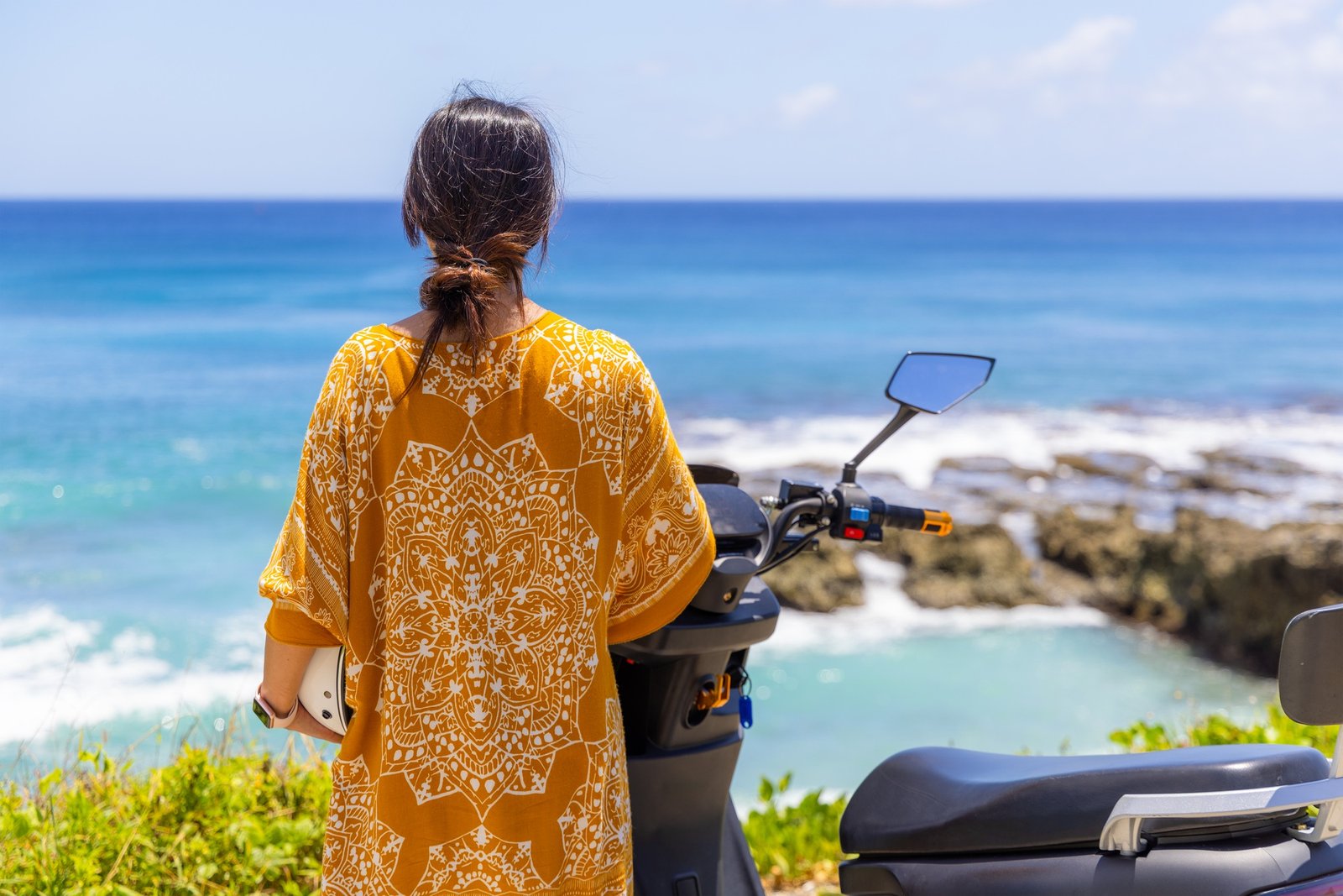 Woman enjoy the sea view with her motor bike